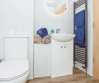 a bathroom with a sink and a toilet and a mirror at Caul View Apartment in Dumfries