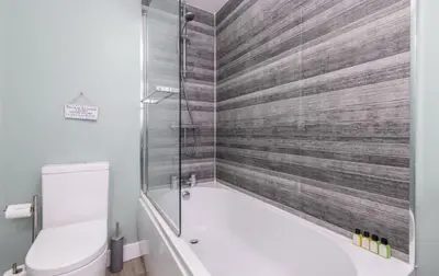 a bathroom with a tub and a toilet and a shower at King George IV Inn in Eskdale