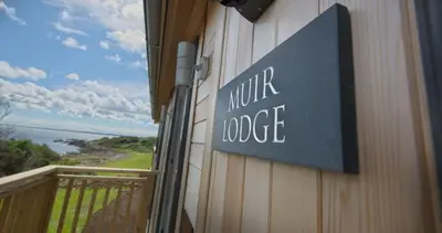 a sign on the side of a building with a balcony at Muir Lodge in Gatehouse of Fleet