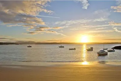 a group of boats in the water at sunset at Muir Lodge in Gatehouse of Fleet