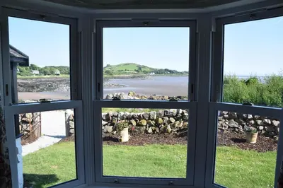 a view from a window looking out at the water at Munro Cottage in Rockcliffe