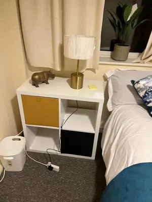 a nightstand with a cat on it next to a bed at IFYLOVESITt2 in Moffat