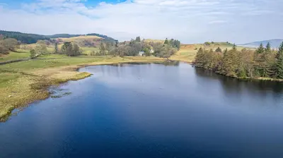 an aerial view of a river in a field at Ornockenoch House in Gatehouse of Fleet