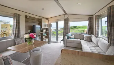 a living room with a couch and a table at Pebbles in Girthon