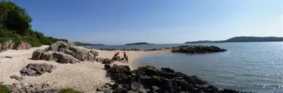 a group of people on a beach near the water at Rocklea in Kippford
