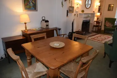 a living room with a wooden table and chairs at Rocklea in Kippford