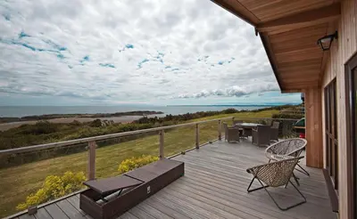 a deck with a bench and a table and chairs at The Buoys in Girthon