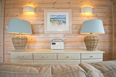 two lamps on top of a dresser with a bed at The Buoys in Girthon