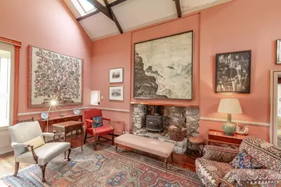 a living room with pink walls and a fireplace at The Mill in Castle Douglas