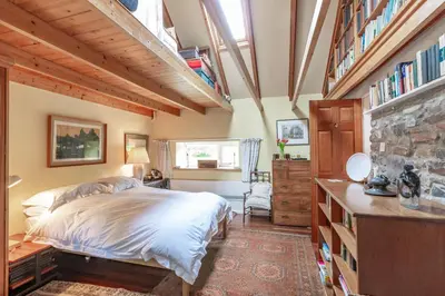 a bedroom with a bed and a stone wall at The Mill in Castle Douglas