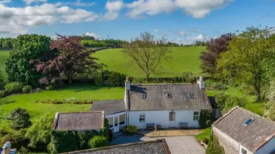 an aerial view of a white house in a field at The Miller's House in Castle Douglas