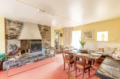 a living room with a table and a fireplace at The Miller's House in Castle Douglas