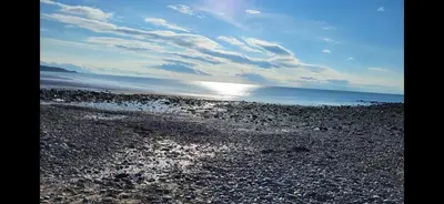 a rocky beach with the sun shining on the water at Hicks Central - Sleeps 2 in Whitehaven