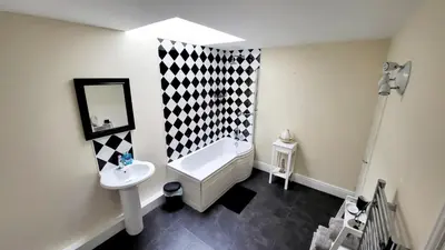 a bathroom with a white tub and a sink at Hicks Central - Sleeps 2 in Whitehaven
