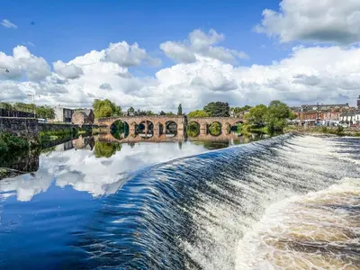 a bridge over a river with a waterfall at Norwood in Thornhill