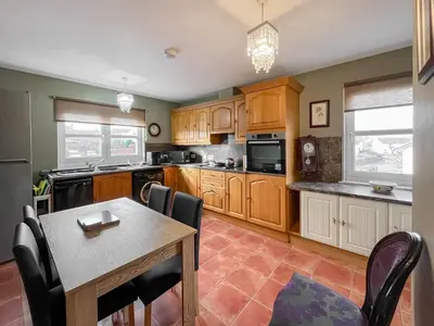 a kitchen with wooden cabinets and a table with chairs at Norwood in Thornhill