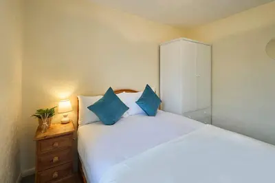 a bedroom with a large white bed with blue pillows at Host & Stay - Trinity Way in Keswick