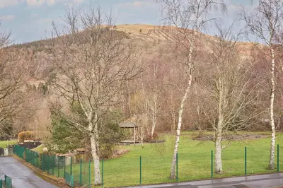 a park with a fence and trees and a gazebo at Host & Stay - Trinity Way in Keswick