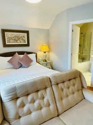 a bedroom with a large bed and a couch at Fairlight Guesthouse in Glenridding