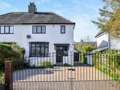 a white house with a wrought iron fence at Hindsgarth in Keswick