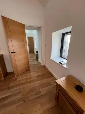 an empty room with a wooden door and a window at Oystercatcher in Dalby