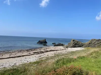 a beach with some rocks in the water at Oystercatcher in Dalby