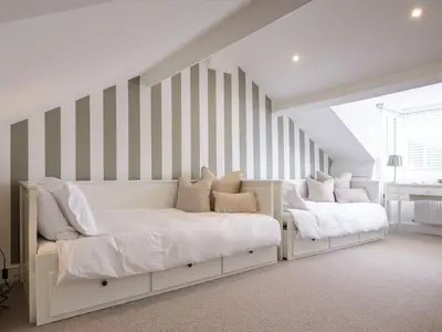 a bedroom with two beds and a striped wall at Skyfell House in Keswick
