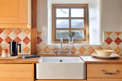 a kitchen with a white sink and a window at Finest Retreats - St Francis Cottage in Ulpha