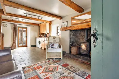 a living room with a stone fireplace in a house at Finest Retreats - St Francis Cottage in Ulpha
