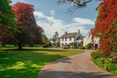 a driveway leading to a white house at Riverside Country House and Cottage in Sunderland