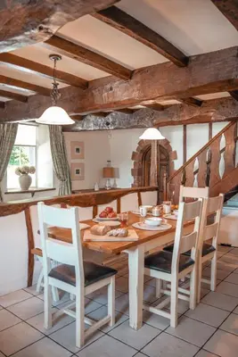 a kitchen and dining room with a wooden table and chairs at Riverside Country House and Cottage in Sunderland