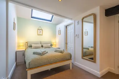 a bedroom with a bed and a mirror at Bell Cottage - Cockermouth is five minutes walk to pubs, restaurants and shops in Cockermouth