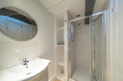 a white bathroom with a sink and a shower at Bell Cottage - Cockermouth is five minutes walk to pubs, restaurants and shops in Cockermouth