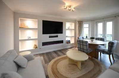 a living room with a couch and a tv at Barassie Bay View apartment in Troon