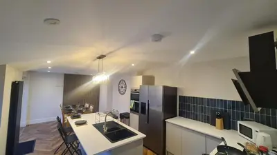 a kitchen with a black refrigerator and a counter top at 5 Bedrooms Sleeps 10 Full Kitchen Parking in Ayr