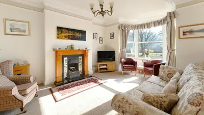 a living room with a couch and a fireplace at Stanley House in Bassenthwaite