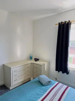 a bedroom with a bed and a dresser and a window at Charming 2br Maisonette In Carlisle Center in Carlisle