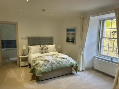 a bedroom with a bed and a window at Underwood House Garden Flat in Kilmarnock