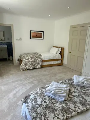 a room with two beds in a room at Underwood House Garden Flat in Kilmarnock