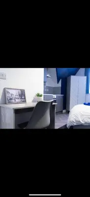a bedroom with a bed and a desk with a laptop at Warwick Studio Spaces in Carlisle