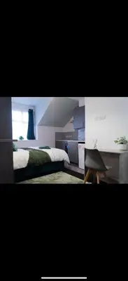a bedroom with a bed and a desk and a chair at Warwick Studio Spaces in Carlisle
