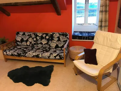 a living room with a couch and a chair at Harbour view retreat in Isle of Whithorn