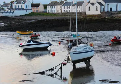 a group of boats tied to a dock in the water at Harbour view retreat in Isle of Whithorn