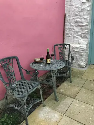 a table with two chairs and a bottle of wine at Harbour view retreat in Isle of Whithorn