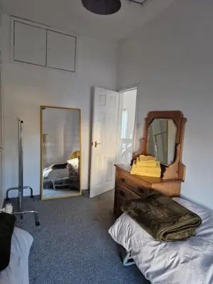 a bedroom with a dresser and a mirror at Victoria Cottage in Whitrigg