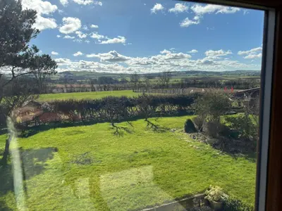 a view of a green field from a window at Kingate Cottage in Aspatria