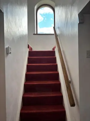 a stairway with a window and a red carpet at Kingate Cottage in Aspatria