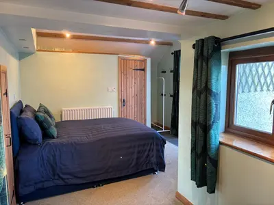 a bedroom with a bed and a window at Kingate Cottage in Aspatria