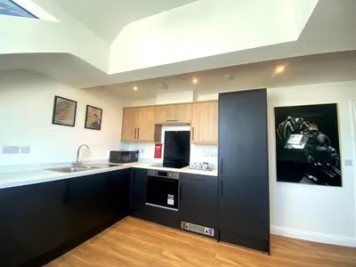 a kitchen with black cabinets and a black refrigerator at 8 Clifton Terrace in Douglas