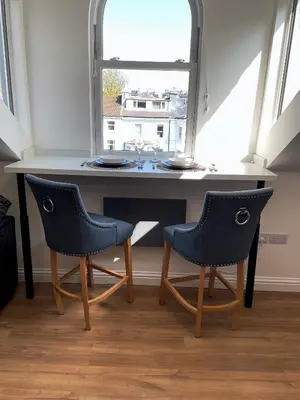 a table with two chairs in front of a window at 8 Clifton Terrace in Douglas